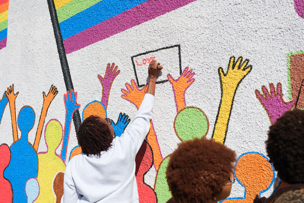 Community members are pictured adding their messages to the placard held by the colourful figures in the Pride mural, during the recent unveiling at Sister Namibia's Windhoek offices.